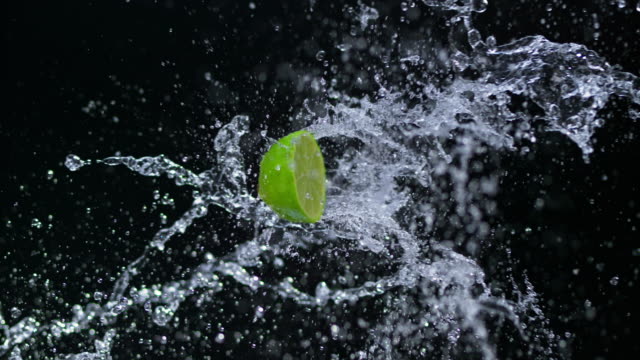 SLO MO Half of lime hitting a water splash in the air