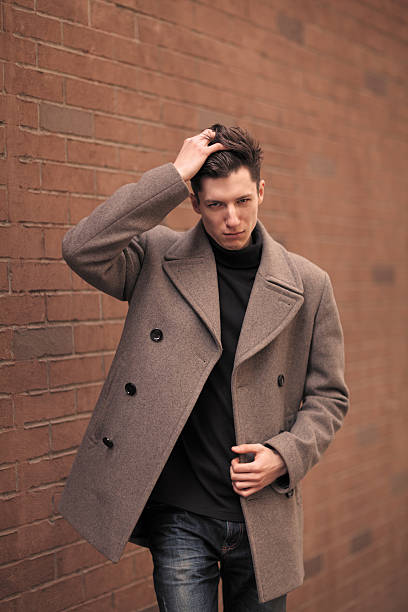 istock Man Model in a coat Poses at a brick wall. 514877191