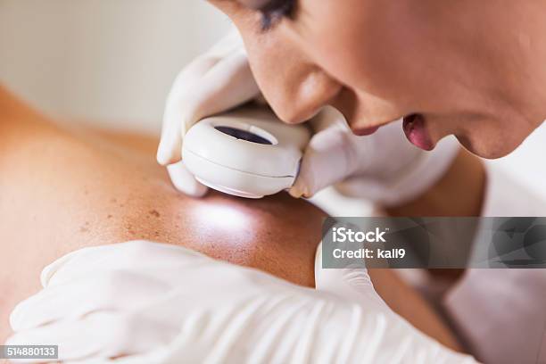 Dermatologist Examining Patient For Signs Of Skin Cancer Stock Photo - Download Image Now