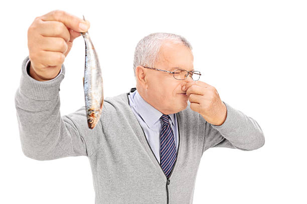 Senior gentleman holding a rotten fish