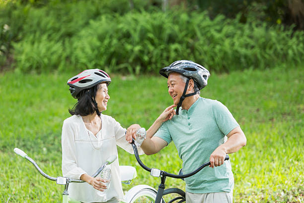 senior casal equitação bicicletas - action mature adult bicycle senior couple imagens e fotografias de stock