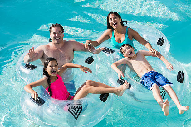 familia en el parque acuático - floating on water swimming pool men water fotografías e imágenes de stock