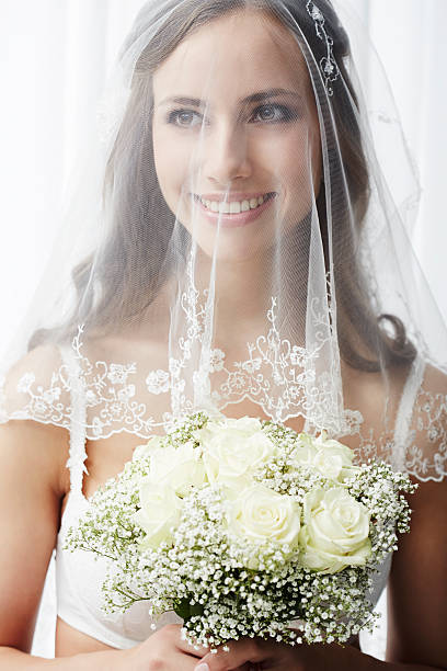 istock Excited young bride in veil holding bouquet 514912085