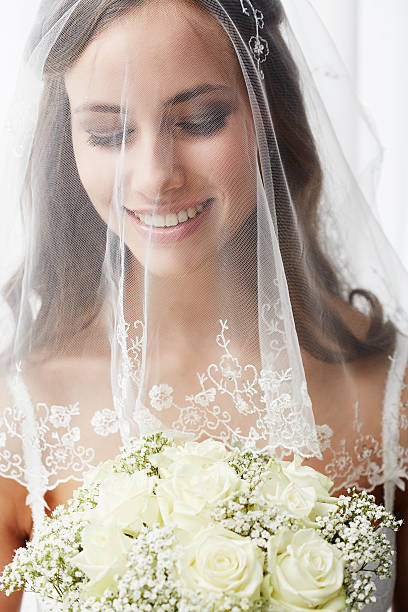 istock Excited young bride in veil holding bouquet 514912087