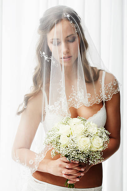 istock Pensive young bride in veil holding bouquet 514912093