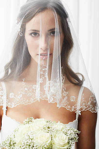 istock Serious young bride in veil holding bouquet 514912967