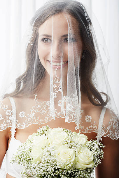 istock Excited young bride in veil holding bouquet 514912969