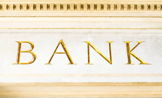 Gold-leaf "BANK" inscription, engraved in marble. Concepts: power, business, wealth.