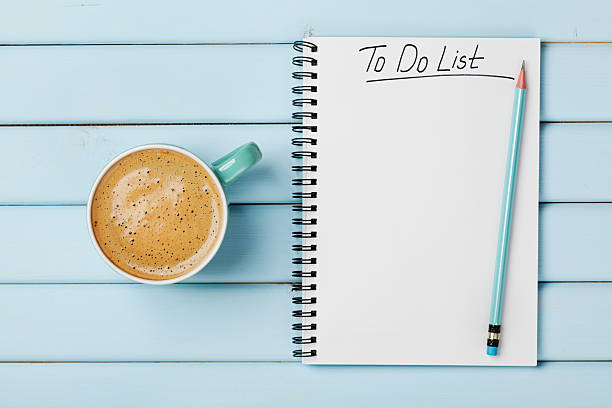 Coffee cup and notebook with to do list, planning concept Coffee cup and notebook with to do list on blue rustic desk from above, planning and design concept to do list stock pictures, royalty-free photos & images