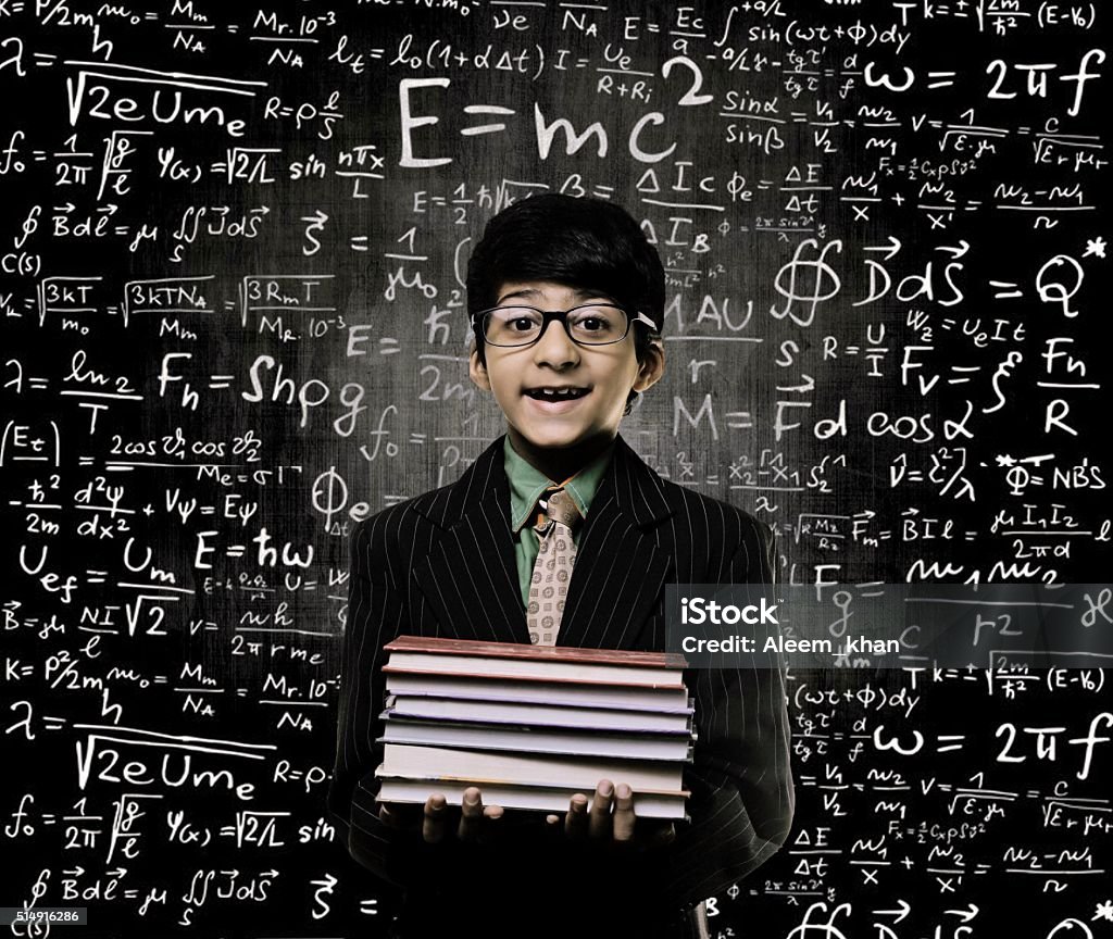 Genius Little Boy Holding Book Wearing Glasses Chalkboard Cute Intelligent Little Boy Holding Book And Wearing Glasses Standing Before A Chalkboard, Chemical Formulas Are Written On Board  Book Stock Photo