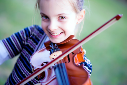 Teenage girl aged 10 is practicing violin in her room