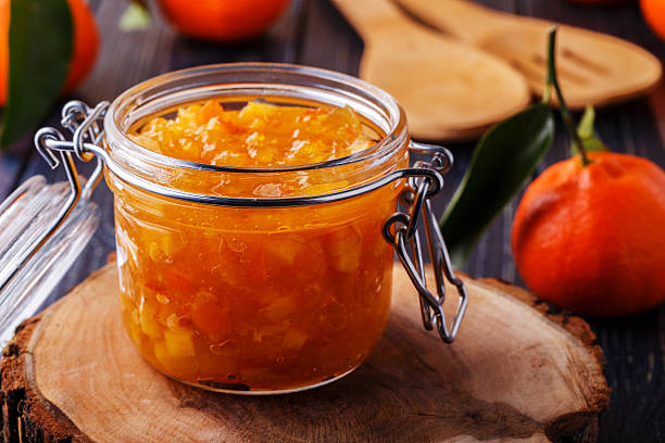 istock Orange (tangerine) jam in a glass jar on the table. 514917866