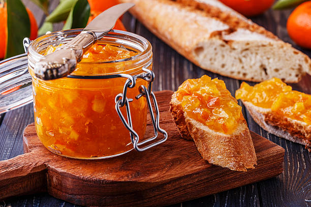 istock Orange (tangerine) jam in a glass jar on the table. 514917912