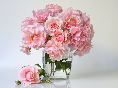 Bouquet of pink roses in a vase. Romantic floral decoration with garden roses.