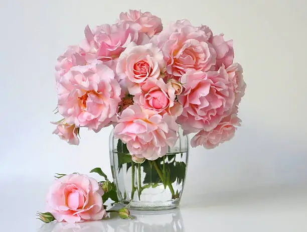 Photo of Bouquet of pink roses in a  vase. Romantic floral decoration.