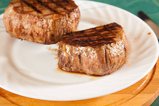 hot fresh grilled boneless rib eye steak isolated on white with barbecue grill marks in the meat