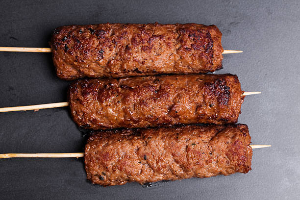 lula kebab on wooden skewers dark baking stock photo