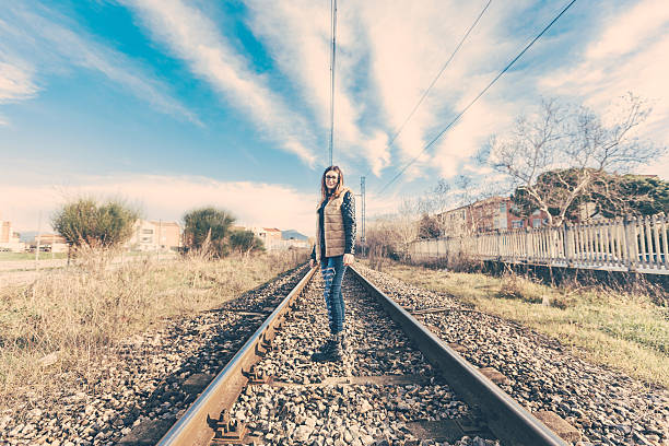 istock Beautiful young woman on railway tracks. 514923444