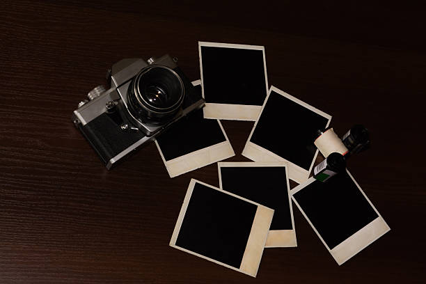 istock Old retro camera with photo frame on wood background 514928214