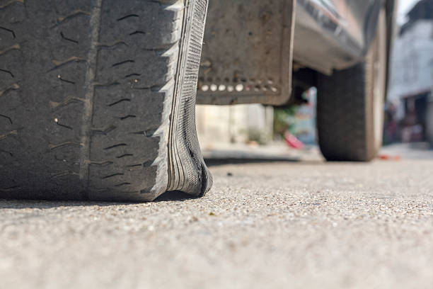 istock burst car tire on street. 514929138