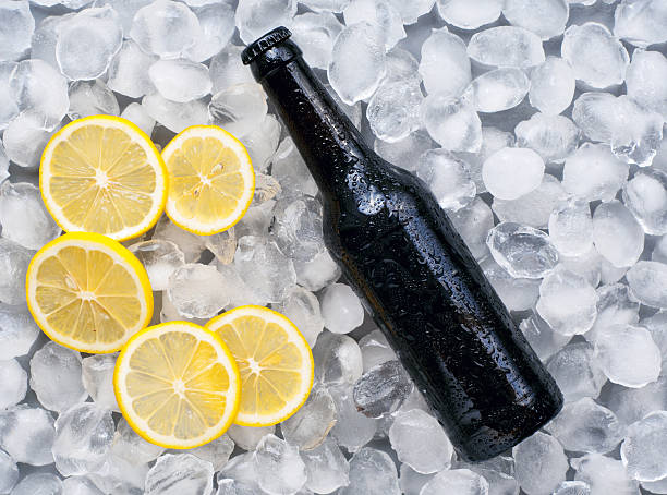 Dark beer bottle with lemon slices in the ice. Top view