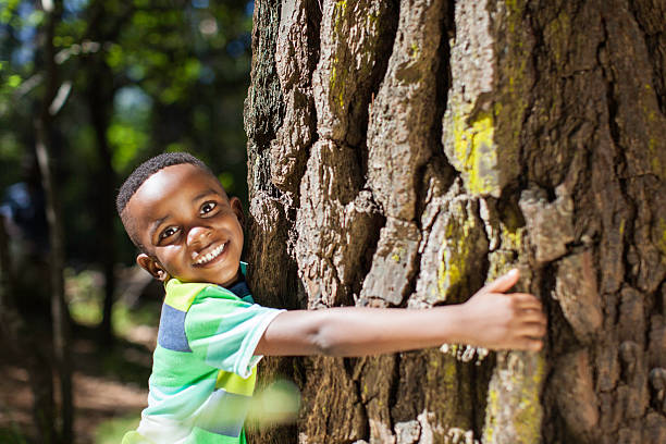 istock African child hugging a tree and smiling at the camera 514930949