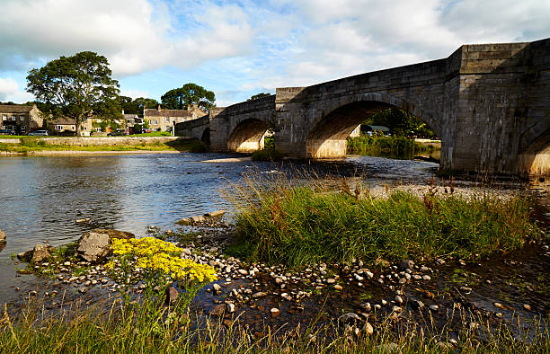Yorkshire Dales Village Scene The view across the River Wharfe towards the pretty village of Burnsall in North Yorkshire. wharfe river photos stock pictures, royalty-free photos & images