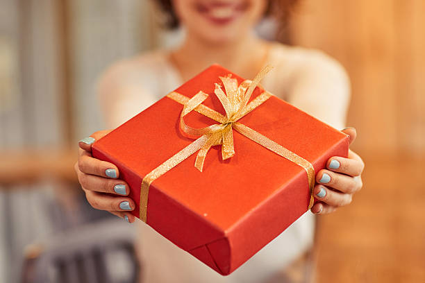 istock Cheerful woman giving present 514932750
