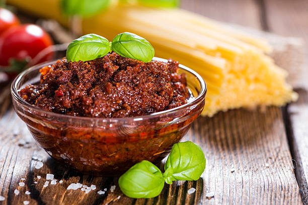 Tomato Pesto Tomato Pesto (with Parmesan Cheese and Garlic) on wooden background pesto sauce stock pictures, royalty-free photos & images