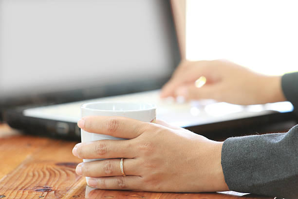 istock Business woman hold a coffee cup and using laptop computer 514933181