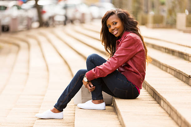 african woman outdoors sitting on steps