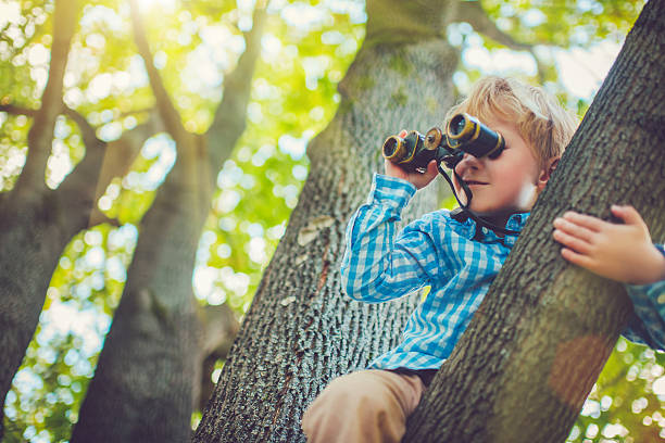 little boy with a binocular - mirar a través fotografías e imágenes de stock