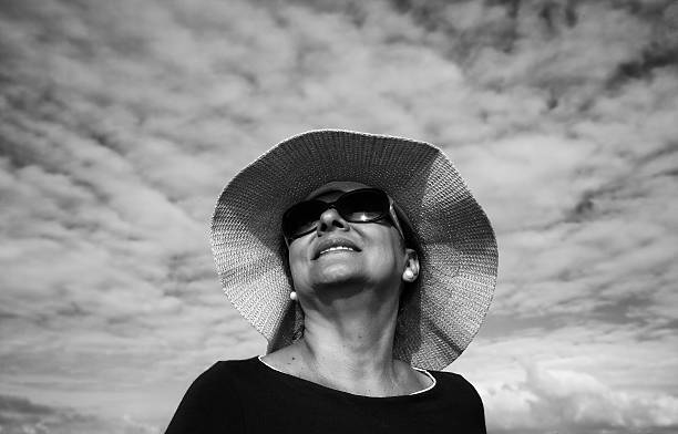 Mature smiling hispanic woman sunglasses and sunhat