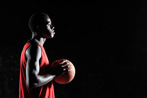 Young basketball player with a ball - side view