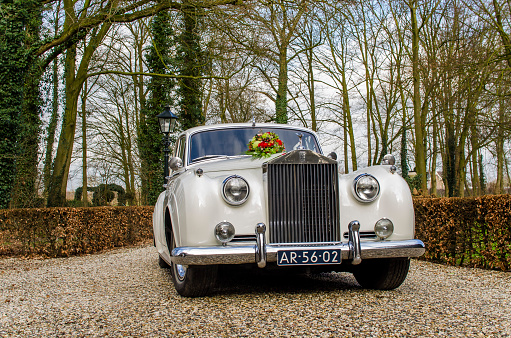 Echteld, The Netherlands - February 12, 2016: A classic Rolls Royce, used as wedding car. On its engine cover a beautiful flower bouquet is attached.