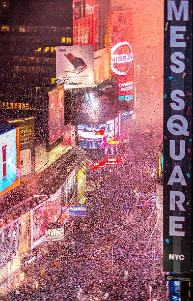Crowds celebrating New Year on Times Square, NYC Crowds celebrating New Year on Times Square, NYC, tons of confetti thrown on the crowds times square new years eve stock pictures, royalty-free photos & images