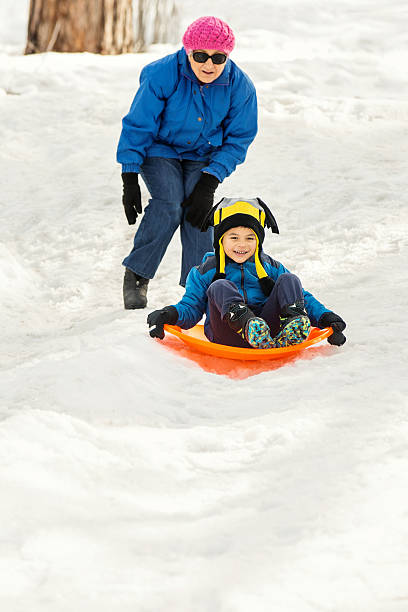 istock Winter Fun: Grandfmother and Grandson Sledding 514940750