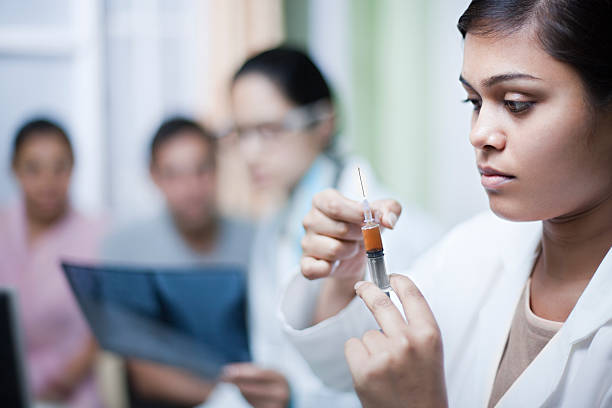 Female assistant doctor preparing injection in clinic.