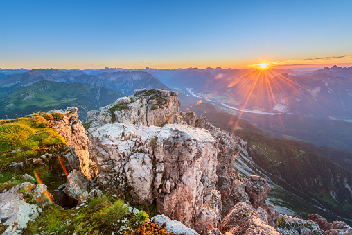 rock with grass on top of tirol mountains at sunset