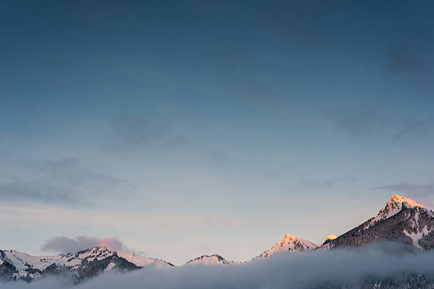 neve laranja picos de montanha no inverno com nevoeiro cadeia - hahnenkamm imagens e fotografias de stock