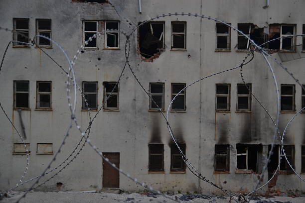 Burned House in ruins behind barbed wire. stock photo