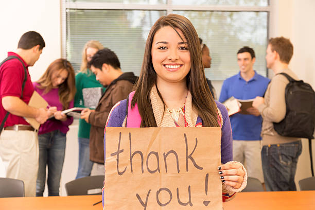 istock Education: Latin descent college student holds 'Thank you' sign. Classroom. 514944488