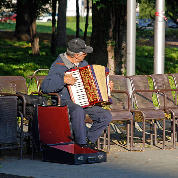 acordeón player sentado en el banco en el parque de la ciudad, viena, austria. - vienna street musician music musician fotografías e imágenes de stock