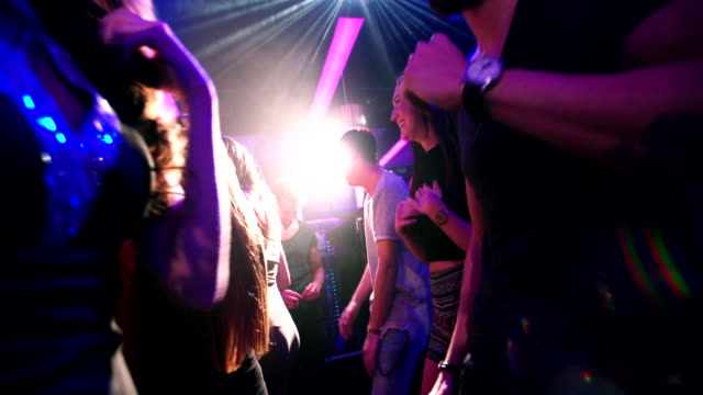 Flythrough shot of energetic party people dancing in club