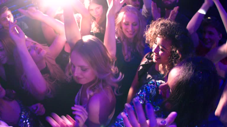 Women and Girls dancing and cheering in club during party