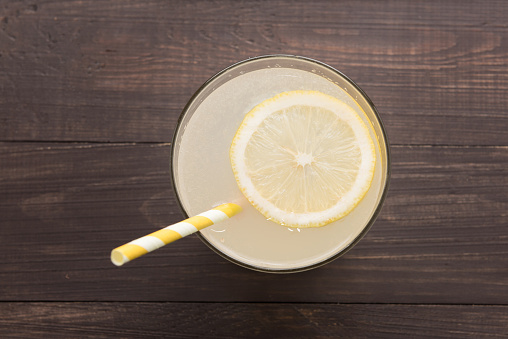 lemonade with fresh slice lemon on wooden background.