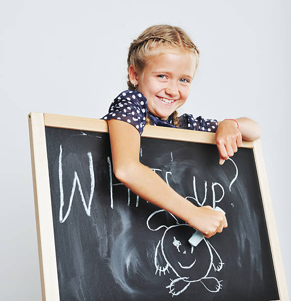 istock Smiling cute school girl drawing. 514989279