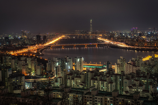 Hazy night view over han river on top of eungbongsan mountain viewpoint. In the distance is the lotte tower, Seoul, South Korea.