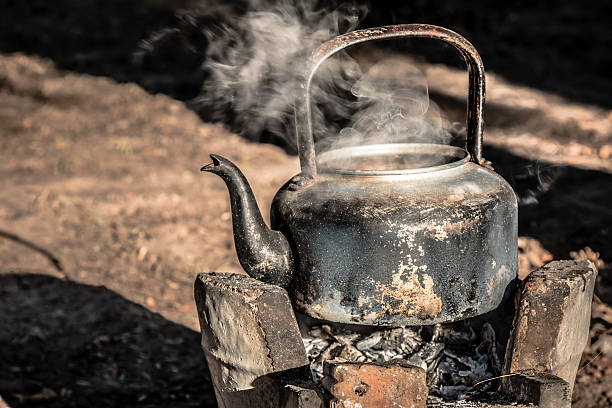 old aluminium kettle on stove, is boiling water. old aluminium kettle on stove.people is boiling water at the countryside in the sunset morning kitchen utensil antique toaster old stock pictures, royalty-free photos & images