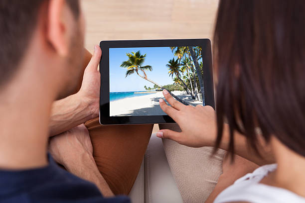 istock Young Couple Looking Photos On Digital Tablet Together 514990977
